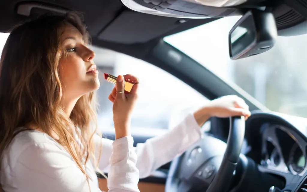 10 Common types of distracted car accidents in Georgia 3 10-common-types-of-distracted-car-accidents-in-Georgia-applying-makeup